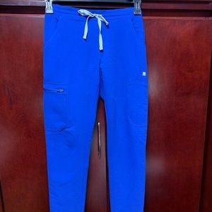 Wear fig scrubs. “Yola Skinny scrub pants” in the color “royal blue”. No returns